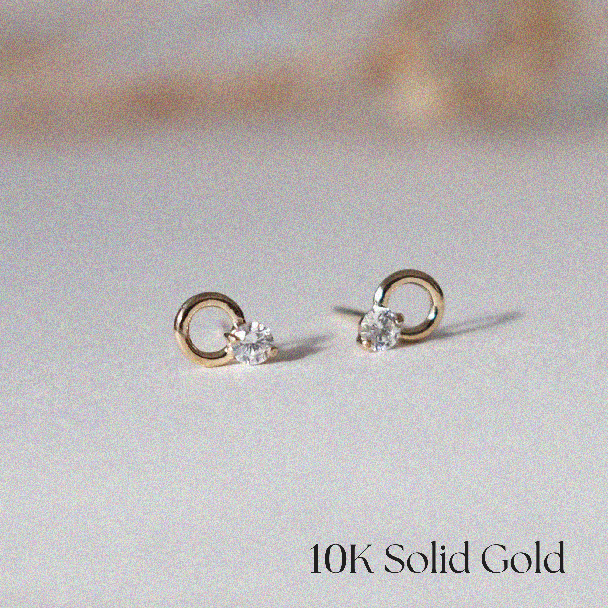 Front view of 10K Eva Earrings with circular gold setting and CZ center