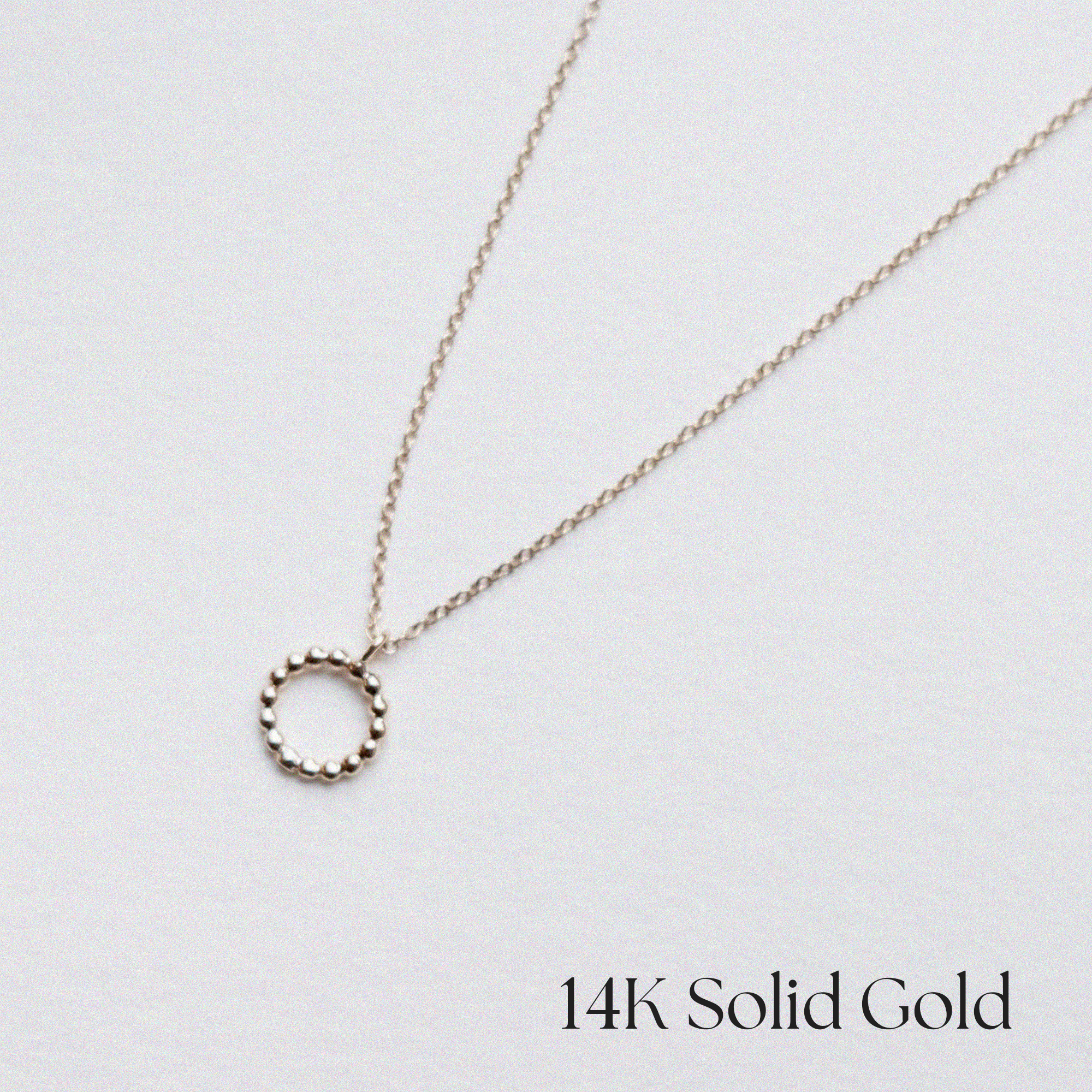 Close-up of the 14K Solid Gold Calla Necklace showing its curved minimalist design