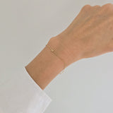Delicate gold bracelet with personalized letter accent on wrist