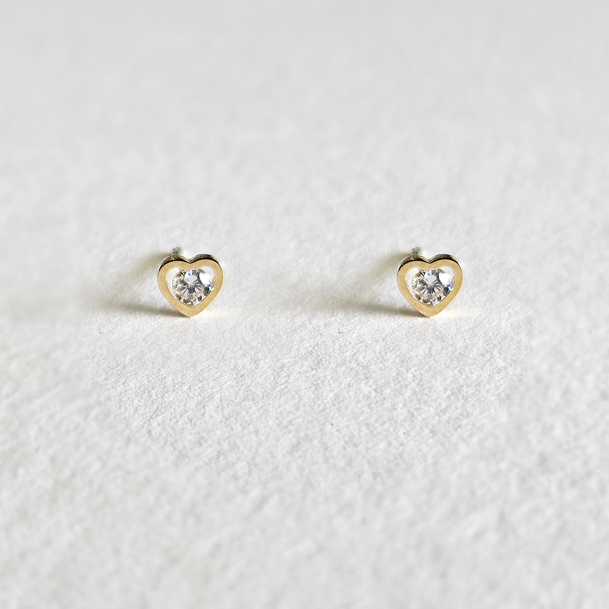Mini heart gold studs with crystal sparkle photographed from front