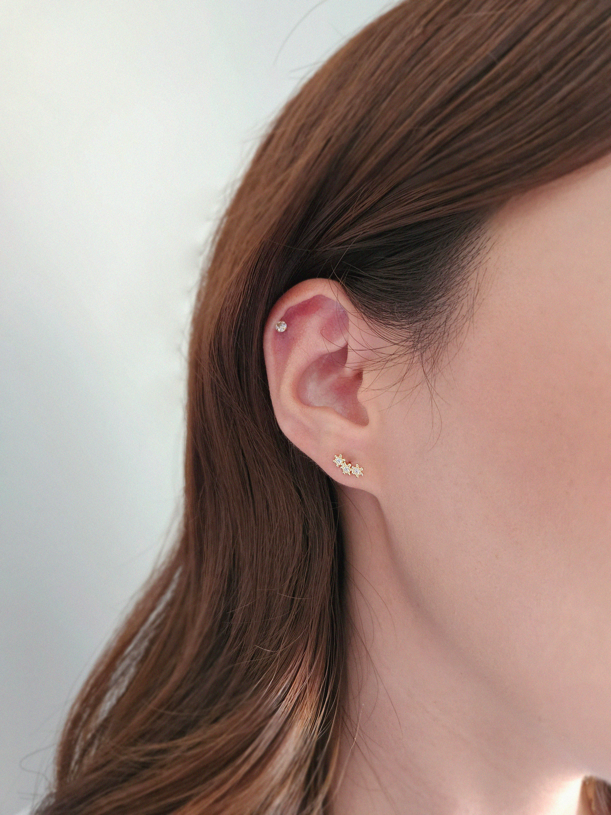 Model wearing Flower Trio earrings for elegant vertical accent"