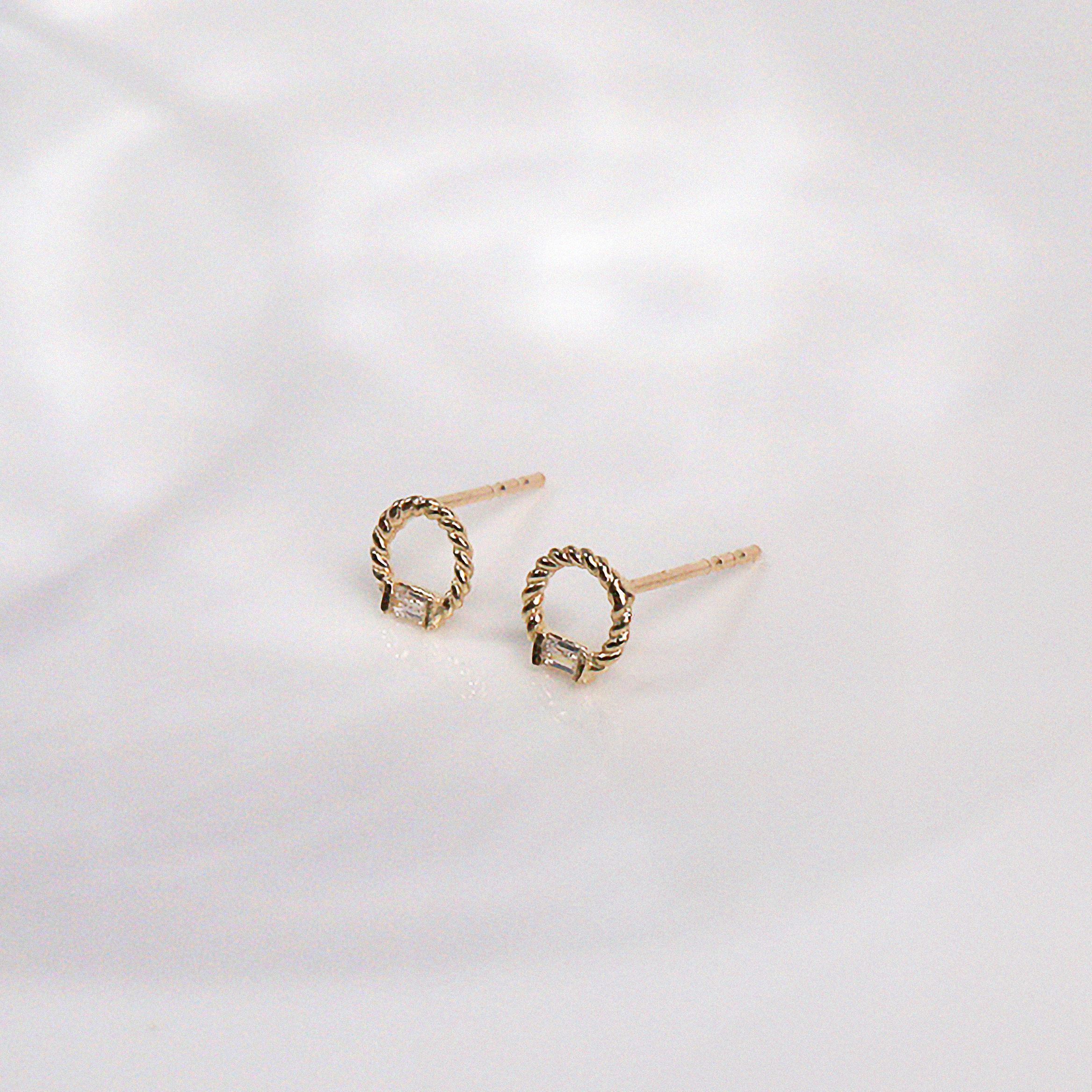 Angled view of gold studs with sparkling center stone