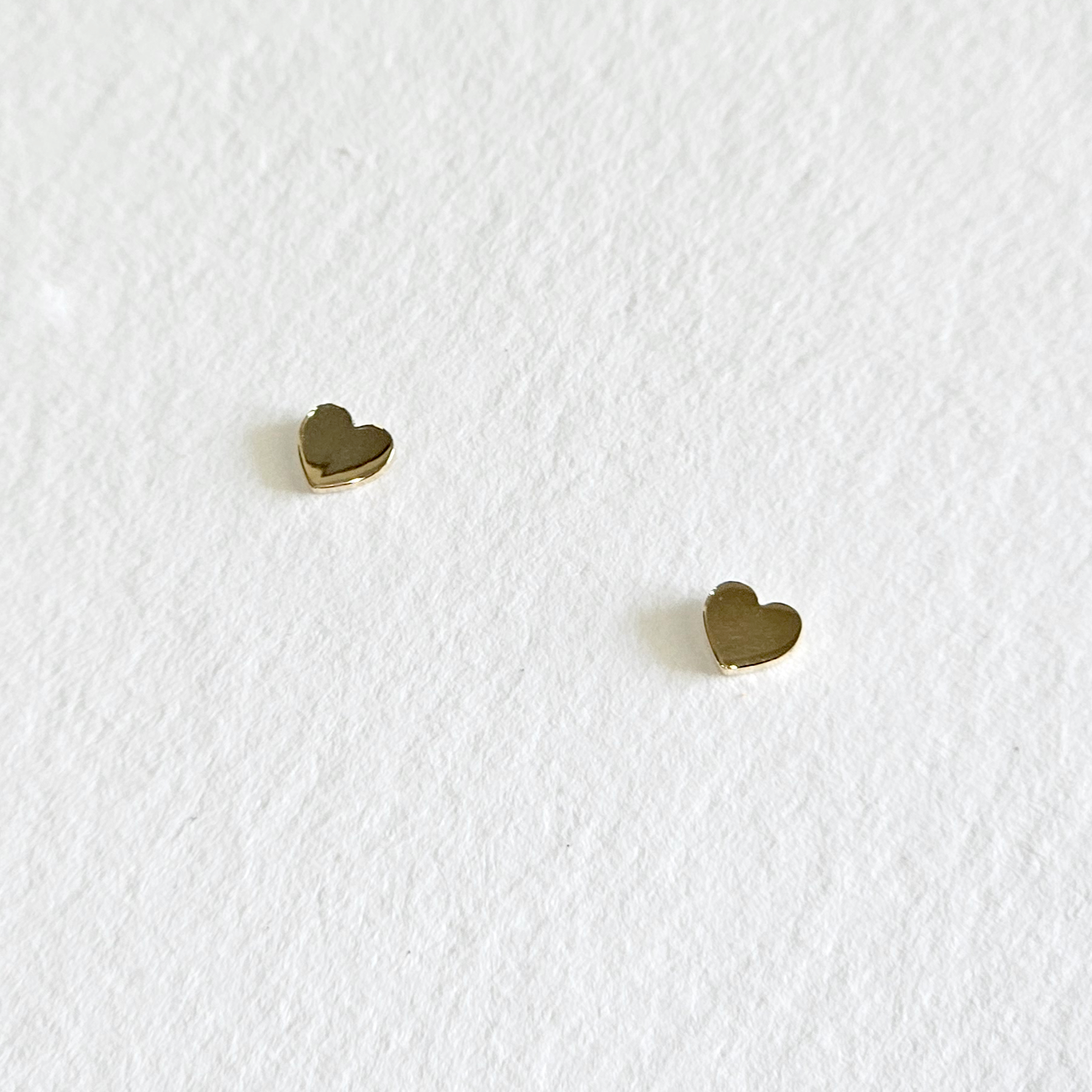 Flat lay of Mini Heart Studs on neutral background