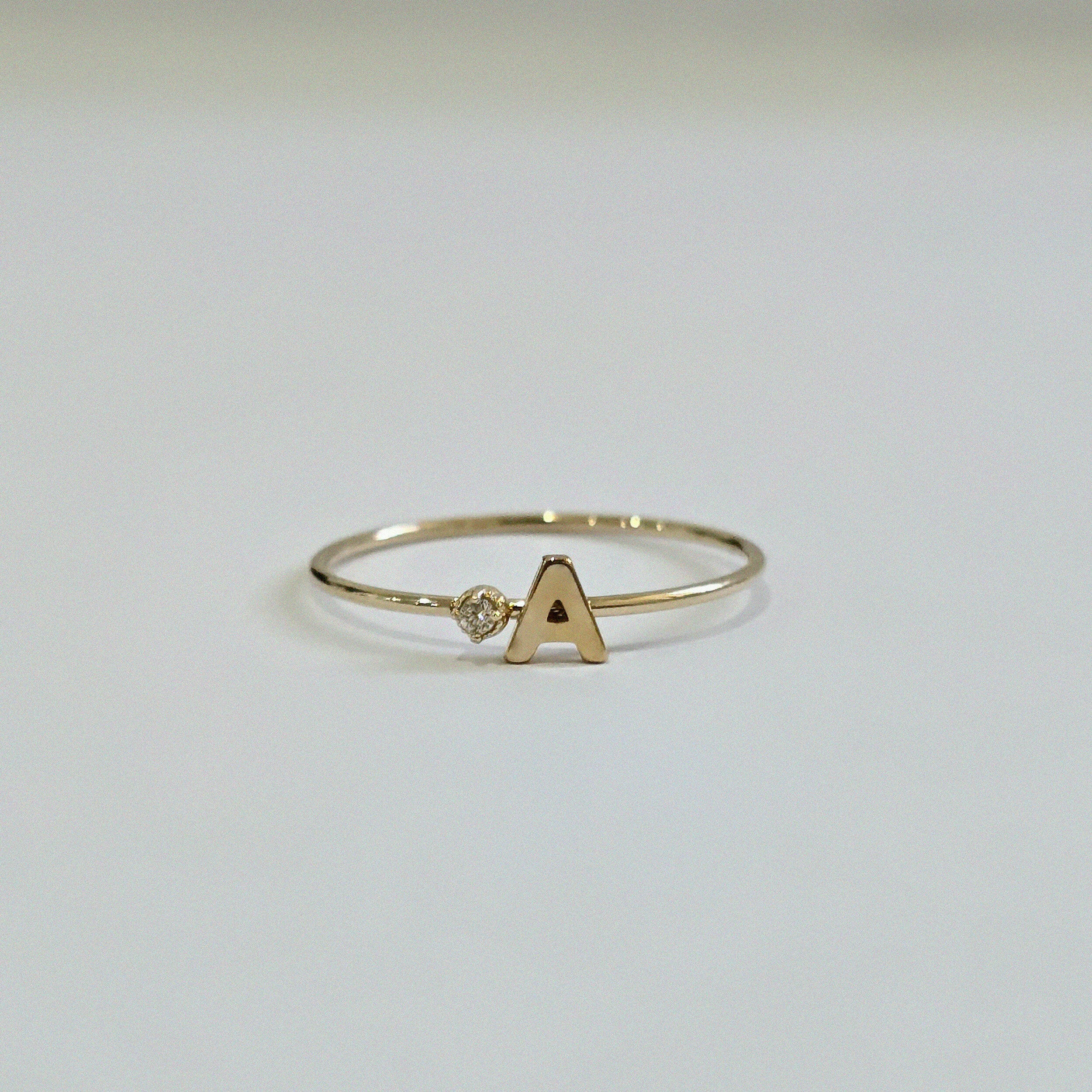 Front view of 14K Initial Ring with diamond accent and polished gold finish