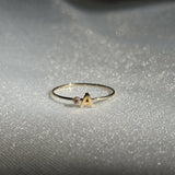 Close-up of personalized gold ring with letter engraving and stone detail