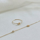 Personalized initial ring presented with initial with diamond bracelet on a soft beigh fabric