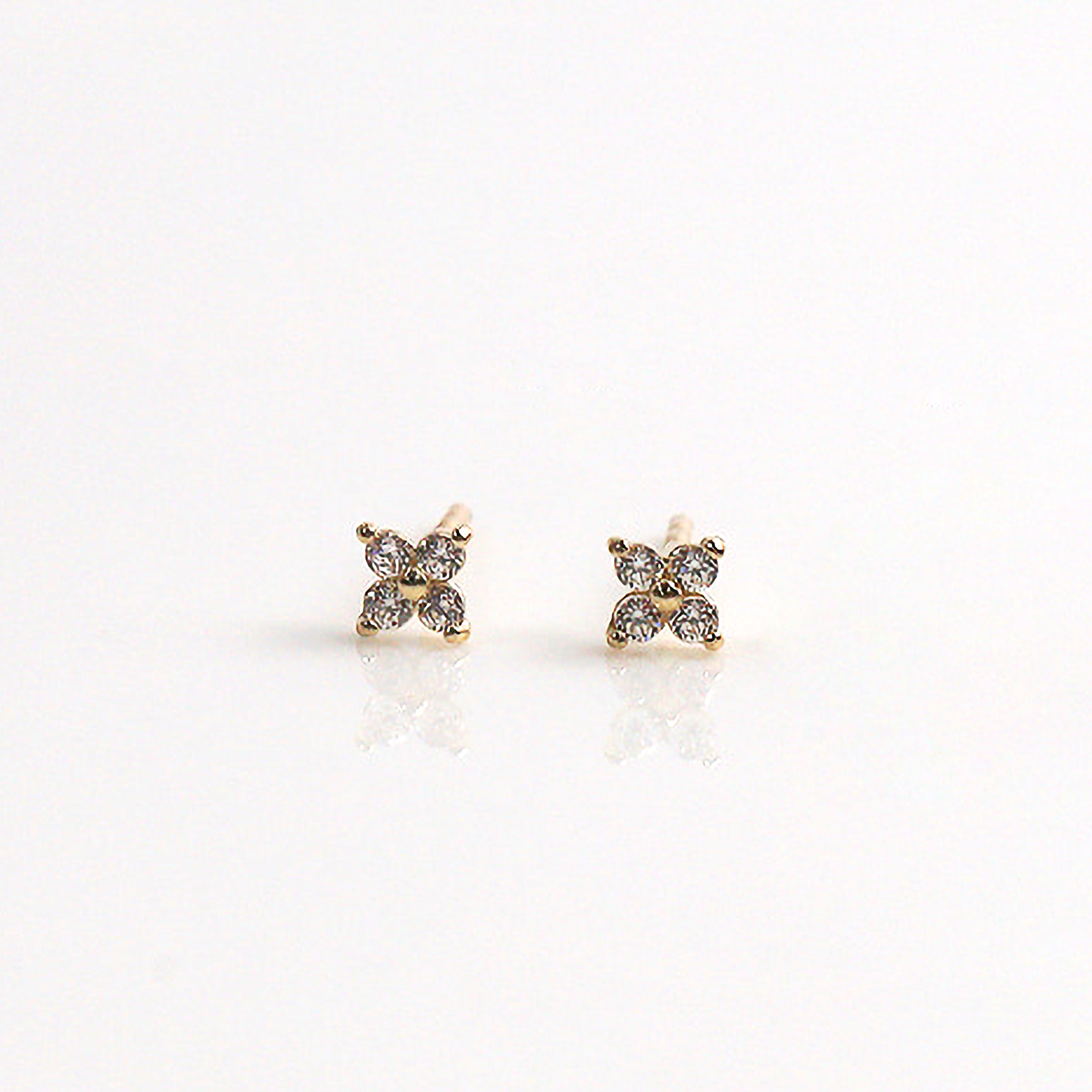 Gold pansy flower earrings photographed from the front