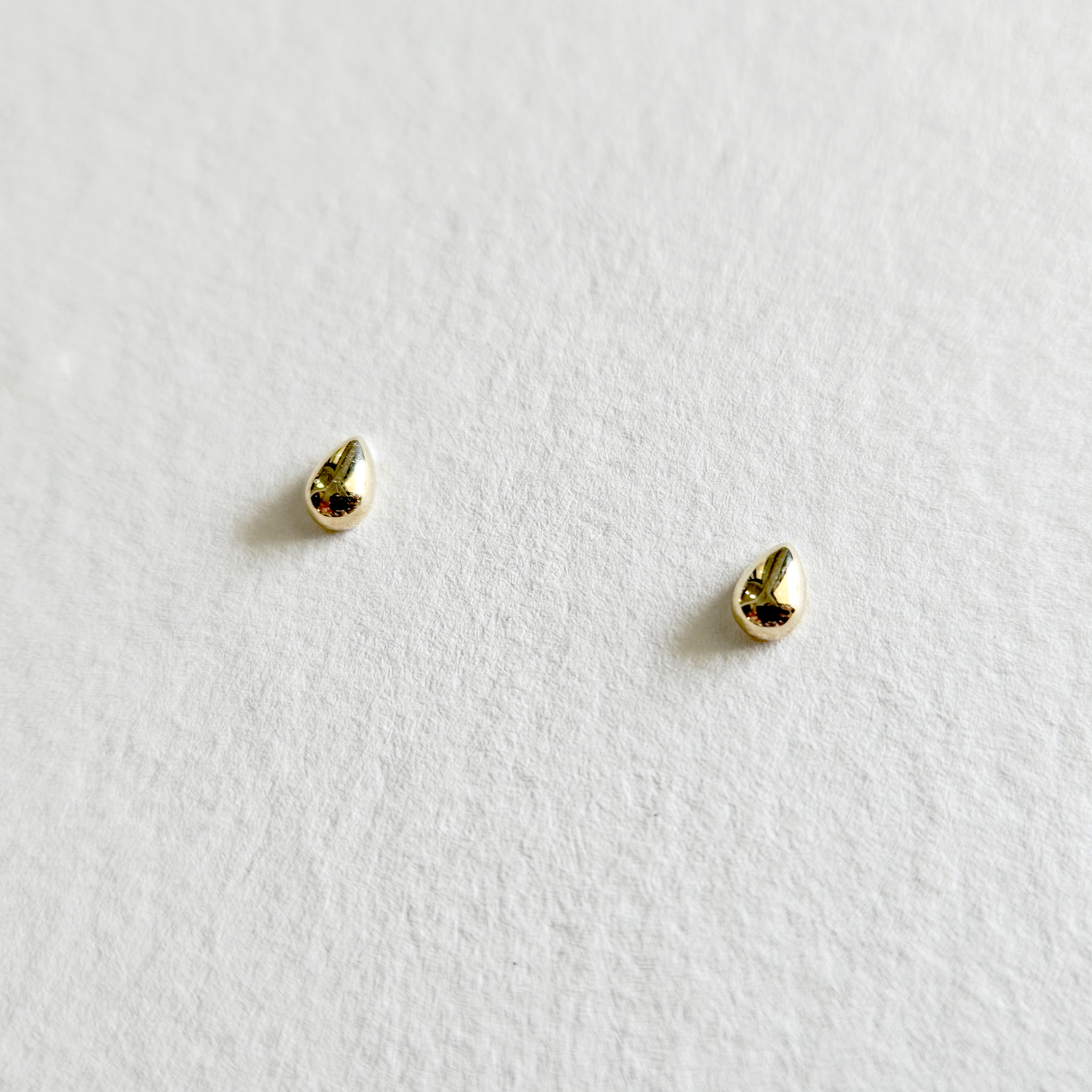 Sculpted gold teardrop earrings viewed from an angle