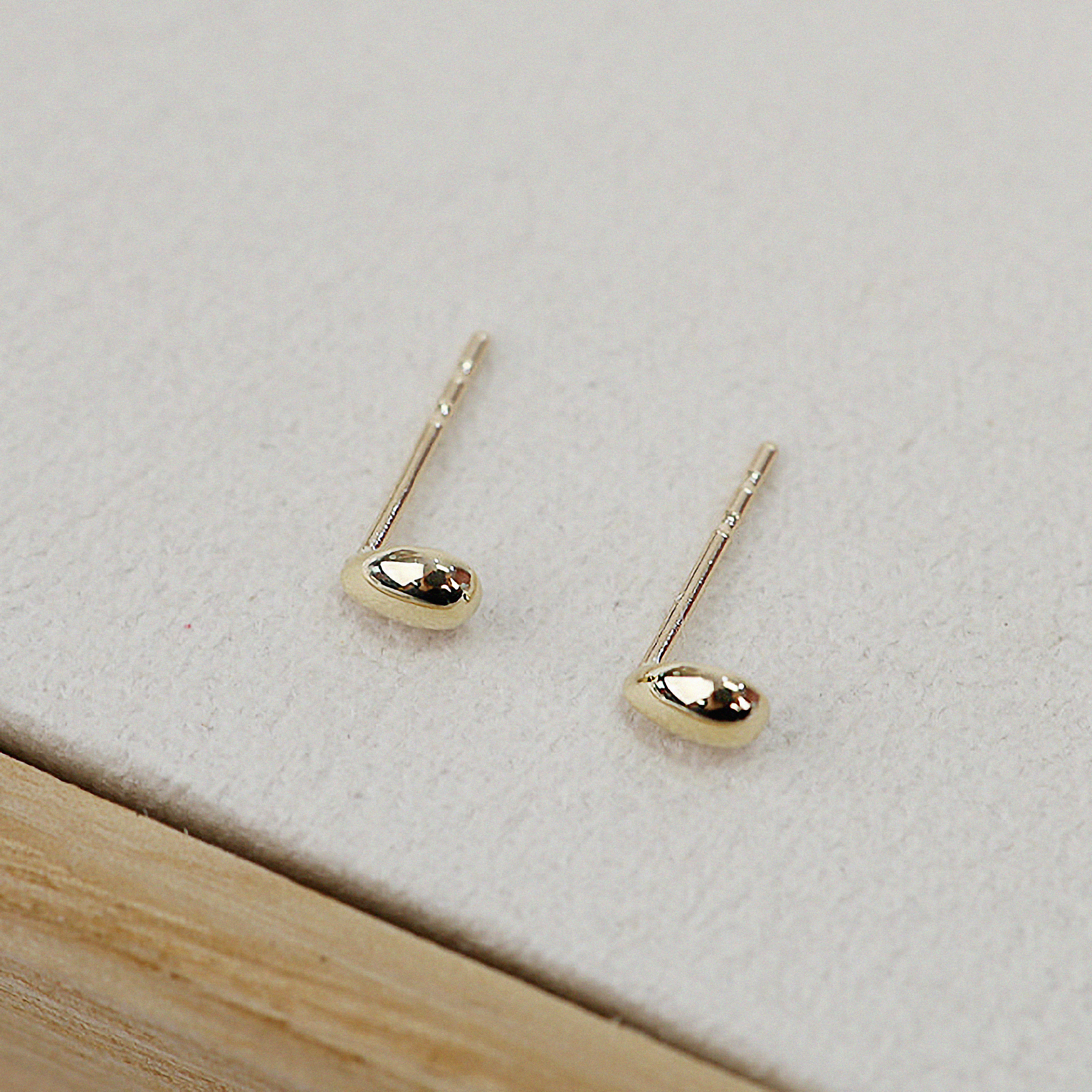 Petite gold earrings arranged from overhead to highlight shape