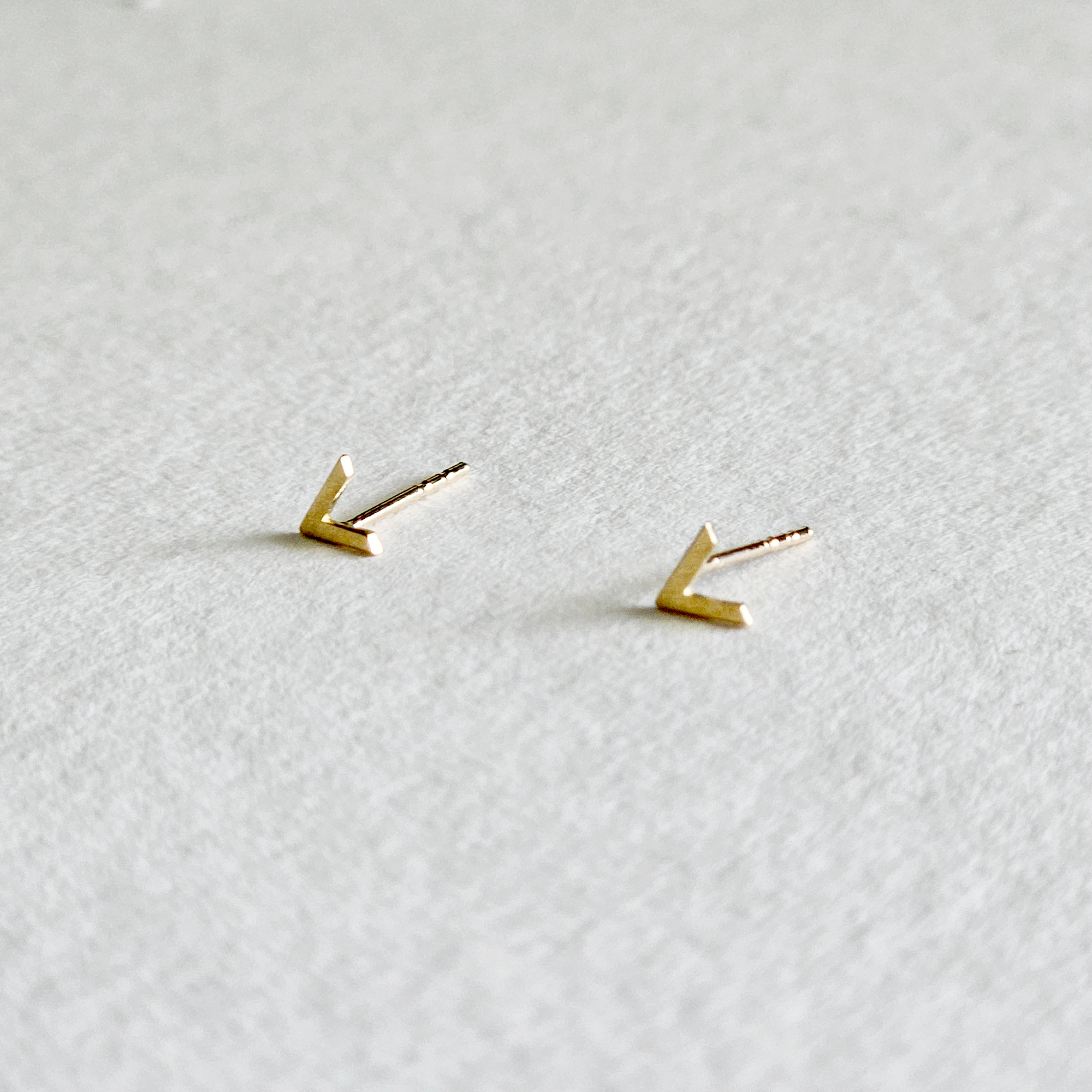 V-shaped gold studs captured from the side