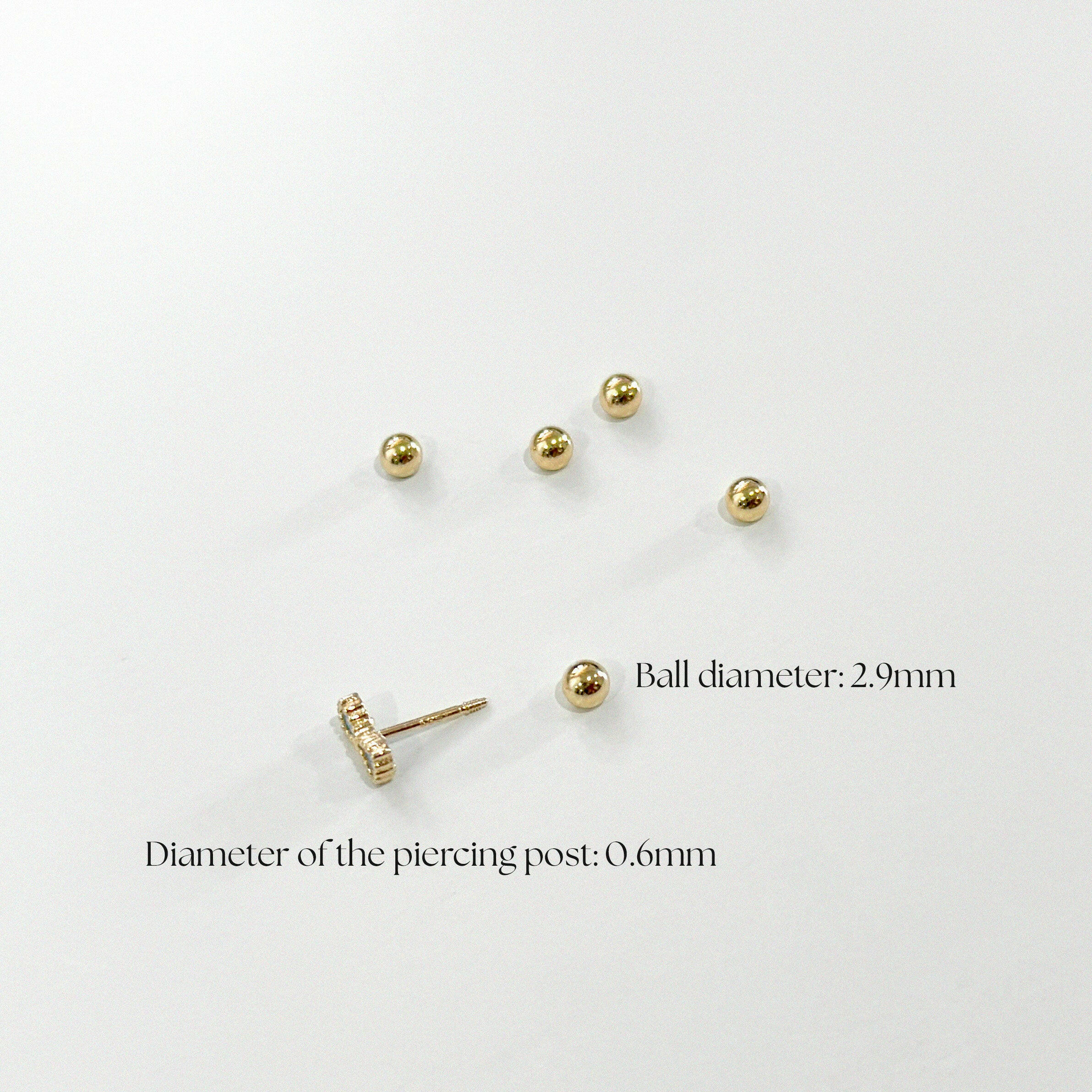 Multiple 14K gold screwball backs and one compatible piercing post displayed on white background with size annotations