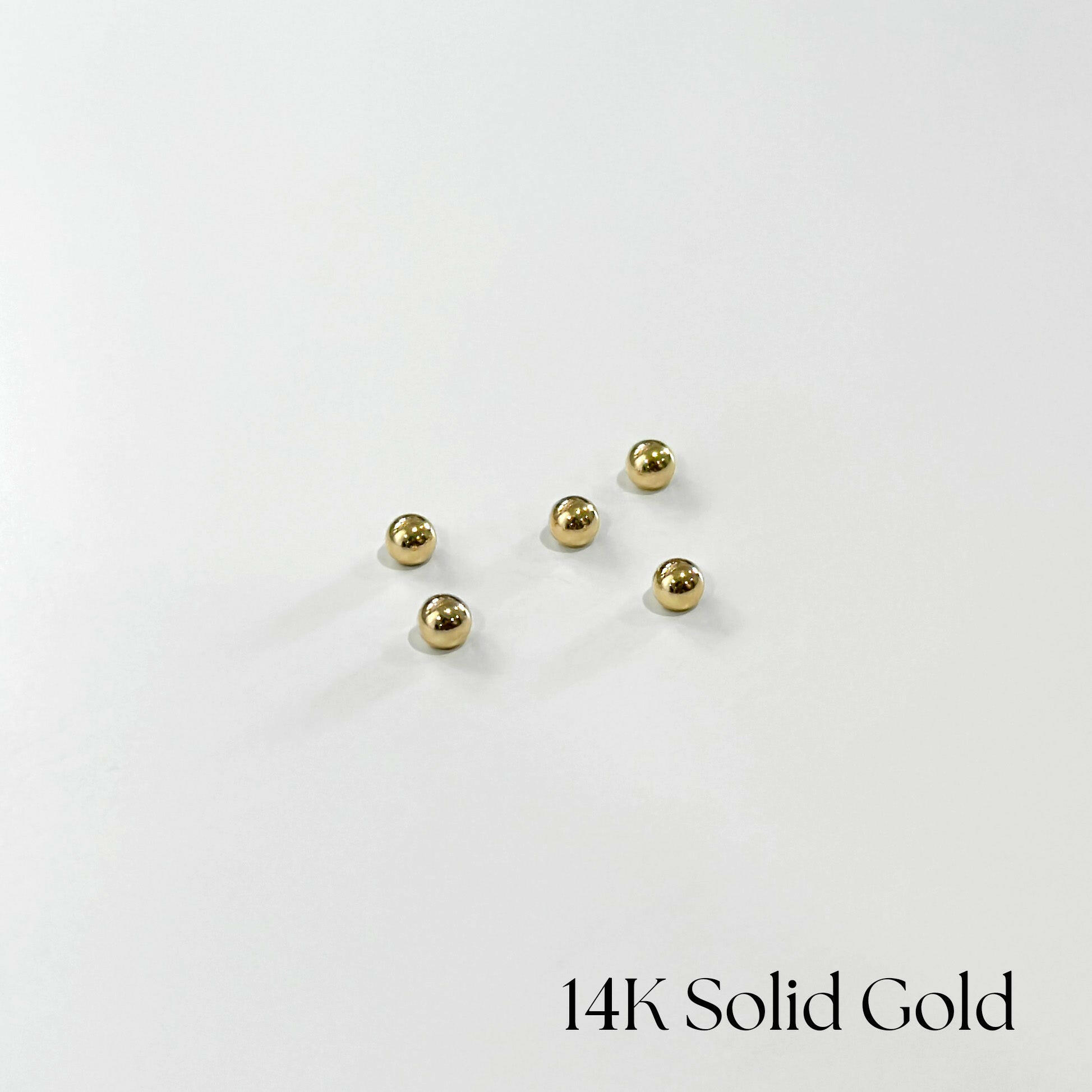 Multiple 14K gold screwball backs on white background