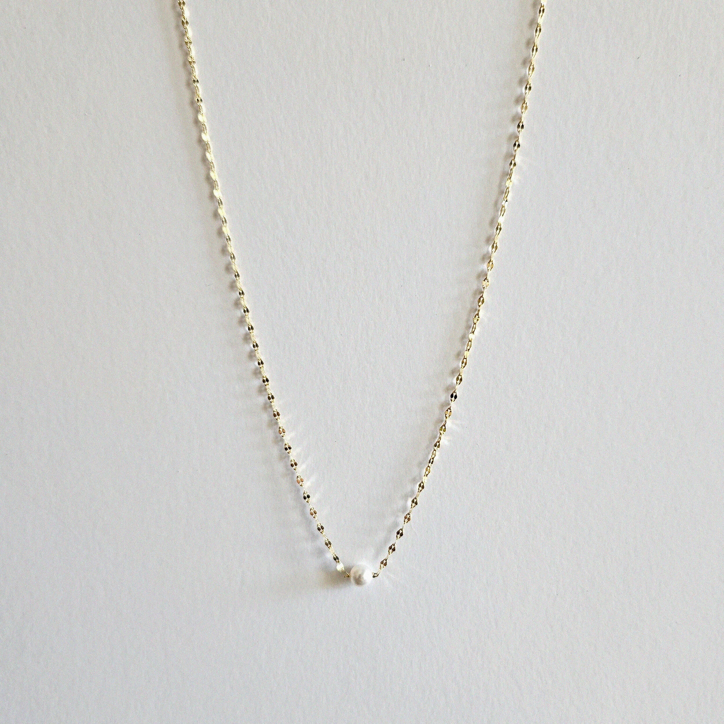 Single pearl necklace exemplifying elegant minimalism, perfect for timeless and sophisticated style.