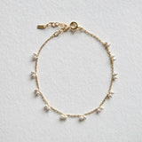 Petite pearl bracelet featuring a pair of lustrous small pearls artfully entwined for elegant style