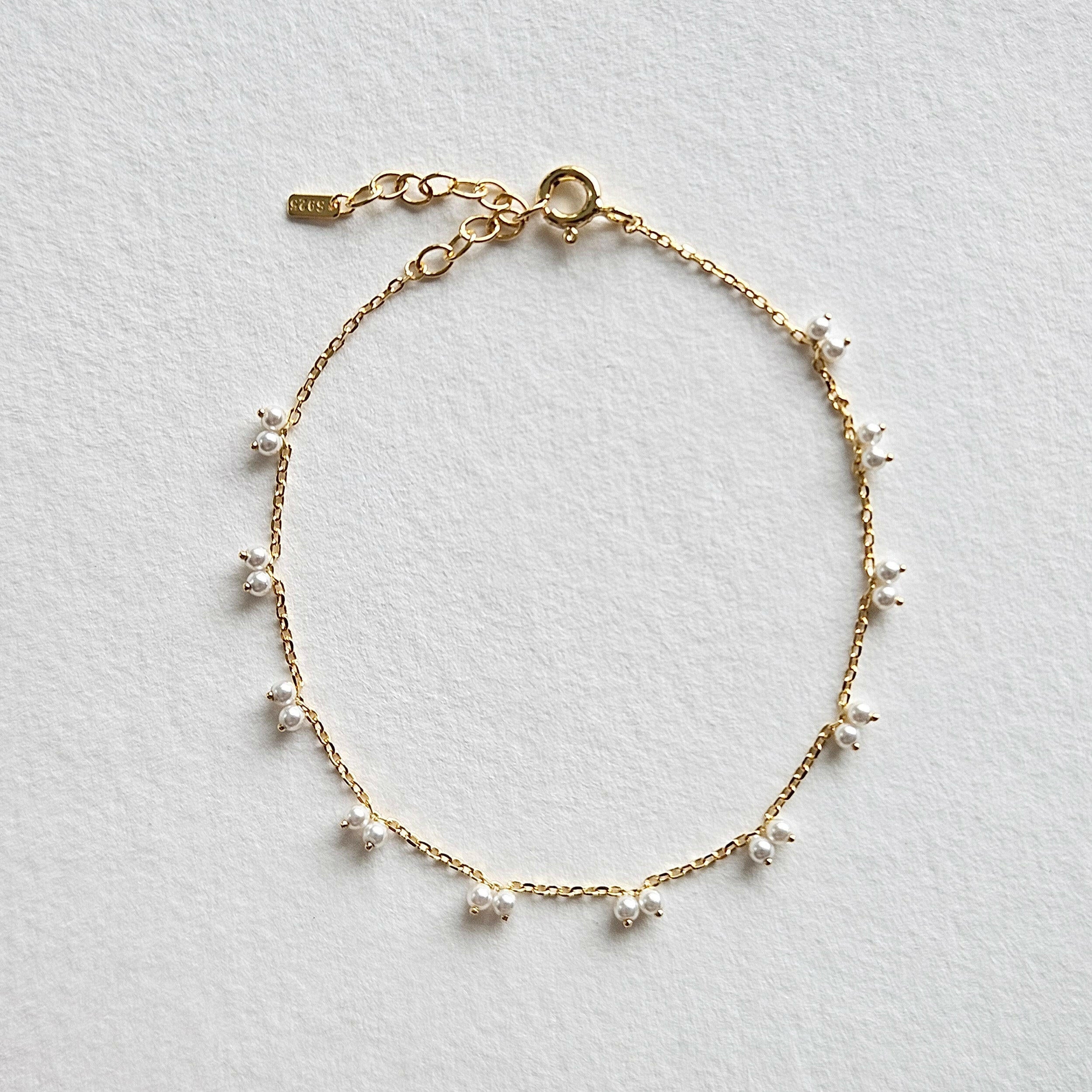 Petite pearl bracelet featuring a pair of lustrous small pearls artfully entwined for elegant style