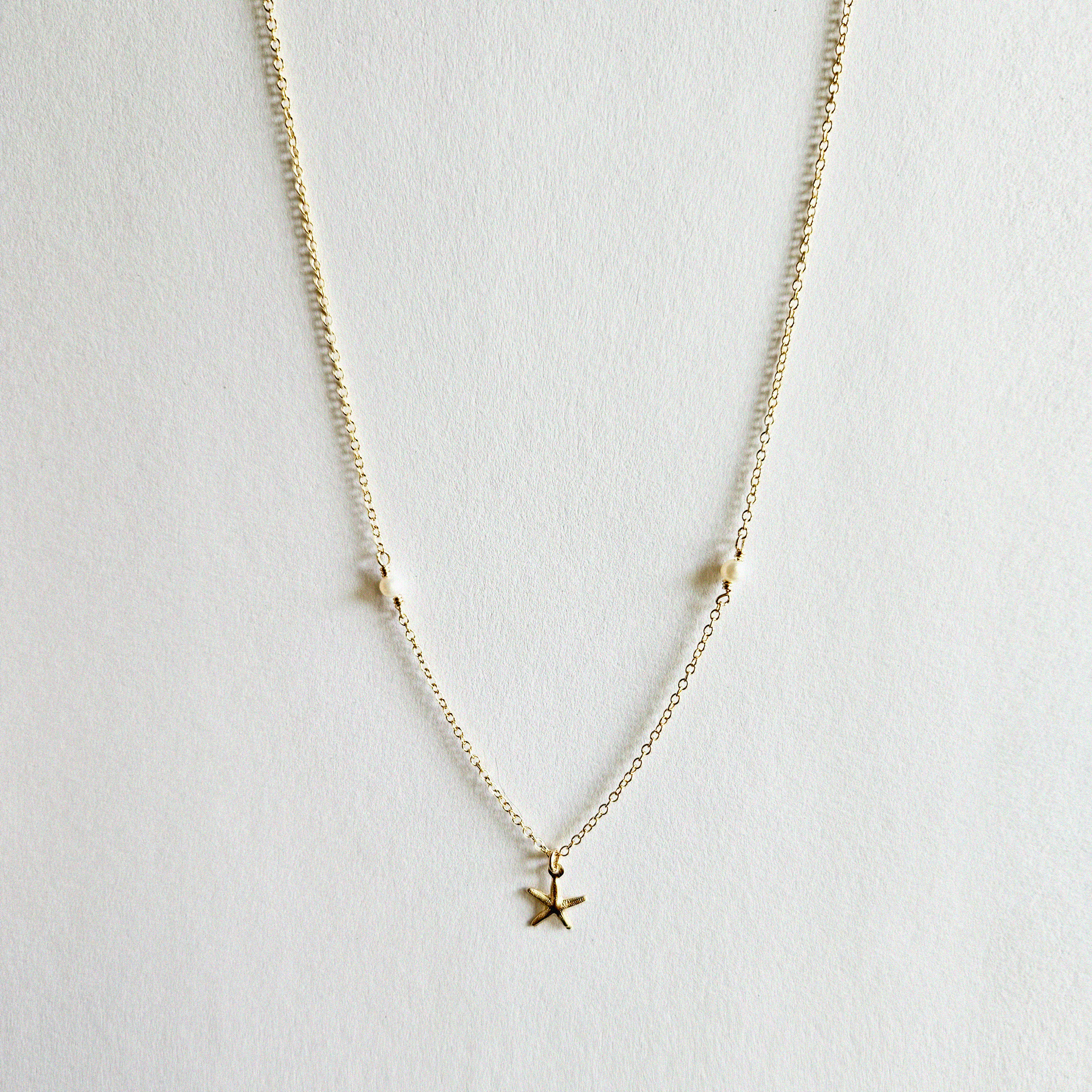 Flat-lay of Under The Sea necklace showcasing charm and chain