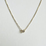 Close-up of petite CZ pendant set in high-polish 14K gold bezel setting