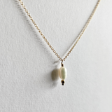 Close-up of pearl and sturdy chain combination on flat lay