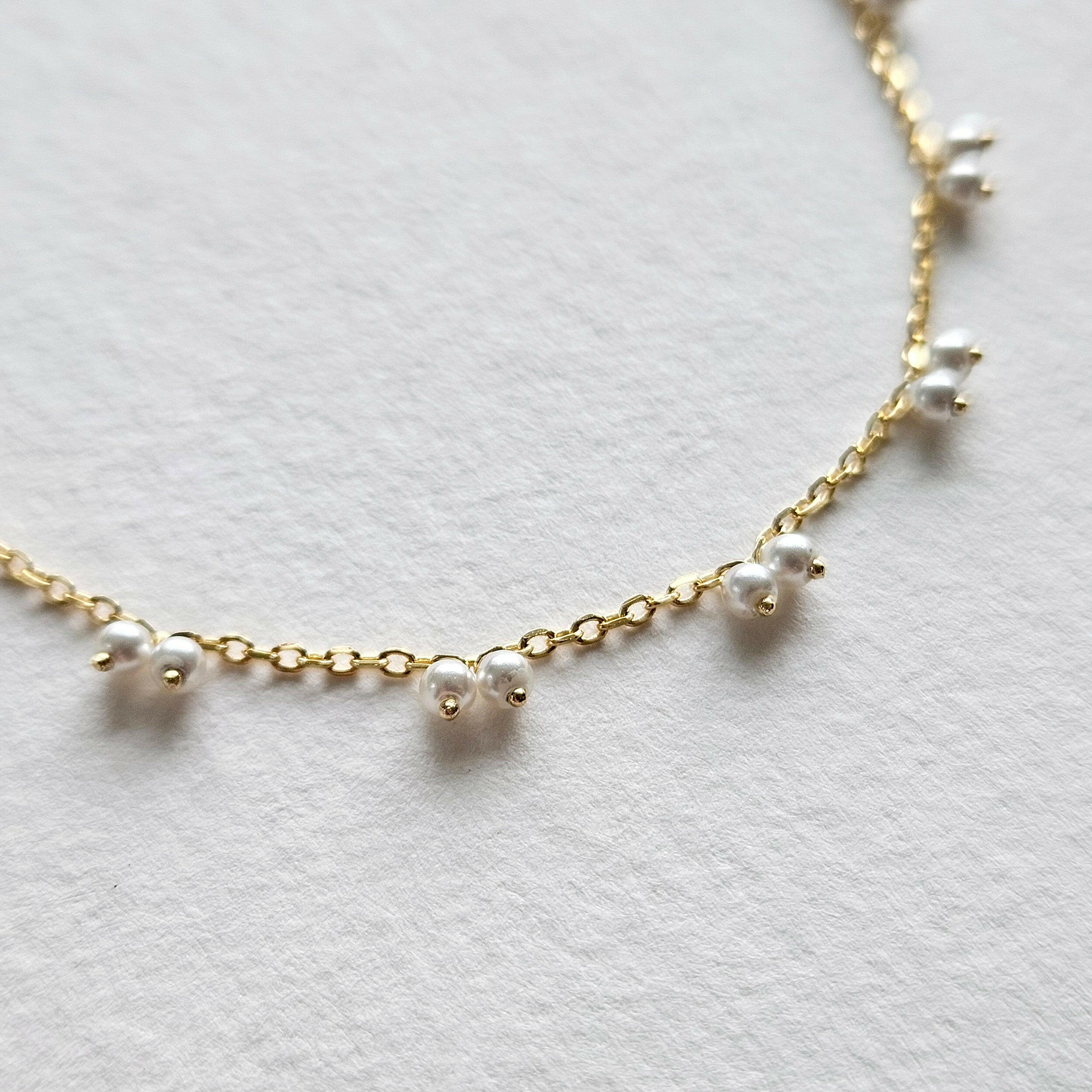 Petite pearl bracelet featuring a pair of lustrous small pearls artfully entwined for elegant style