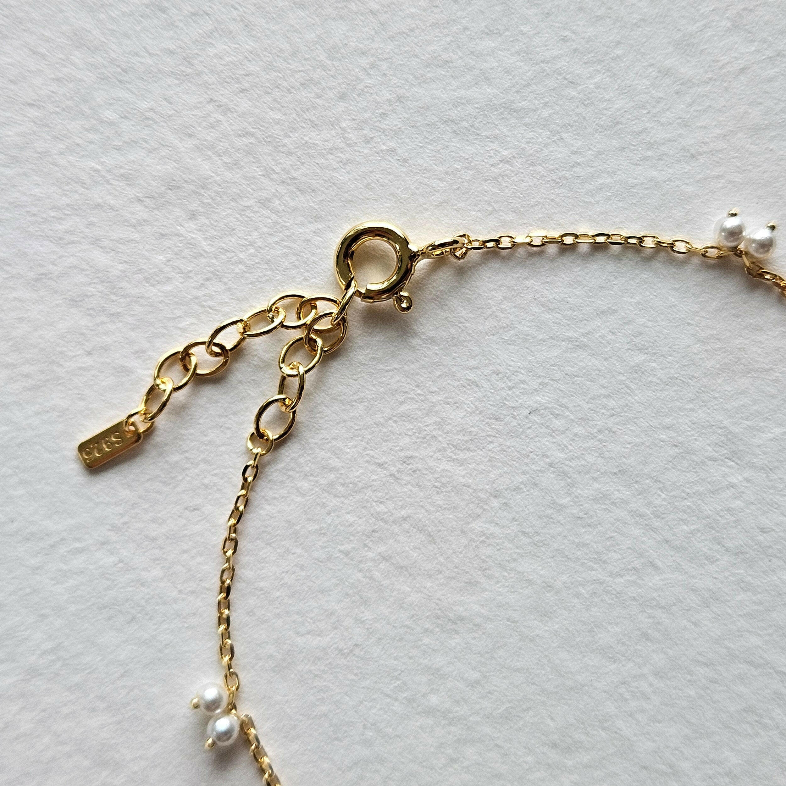Petite pearl bracelet featuring a pair of lustrous small pearls artfully entwined for elegant style