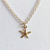 Close-up of starfish charm and pearls with polished finish