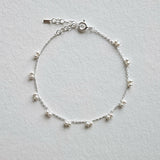 Petite pearl bracelet featuring a pair of lustrous small pearls artfully entwined for elegant style