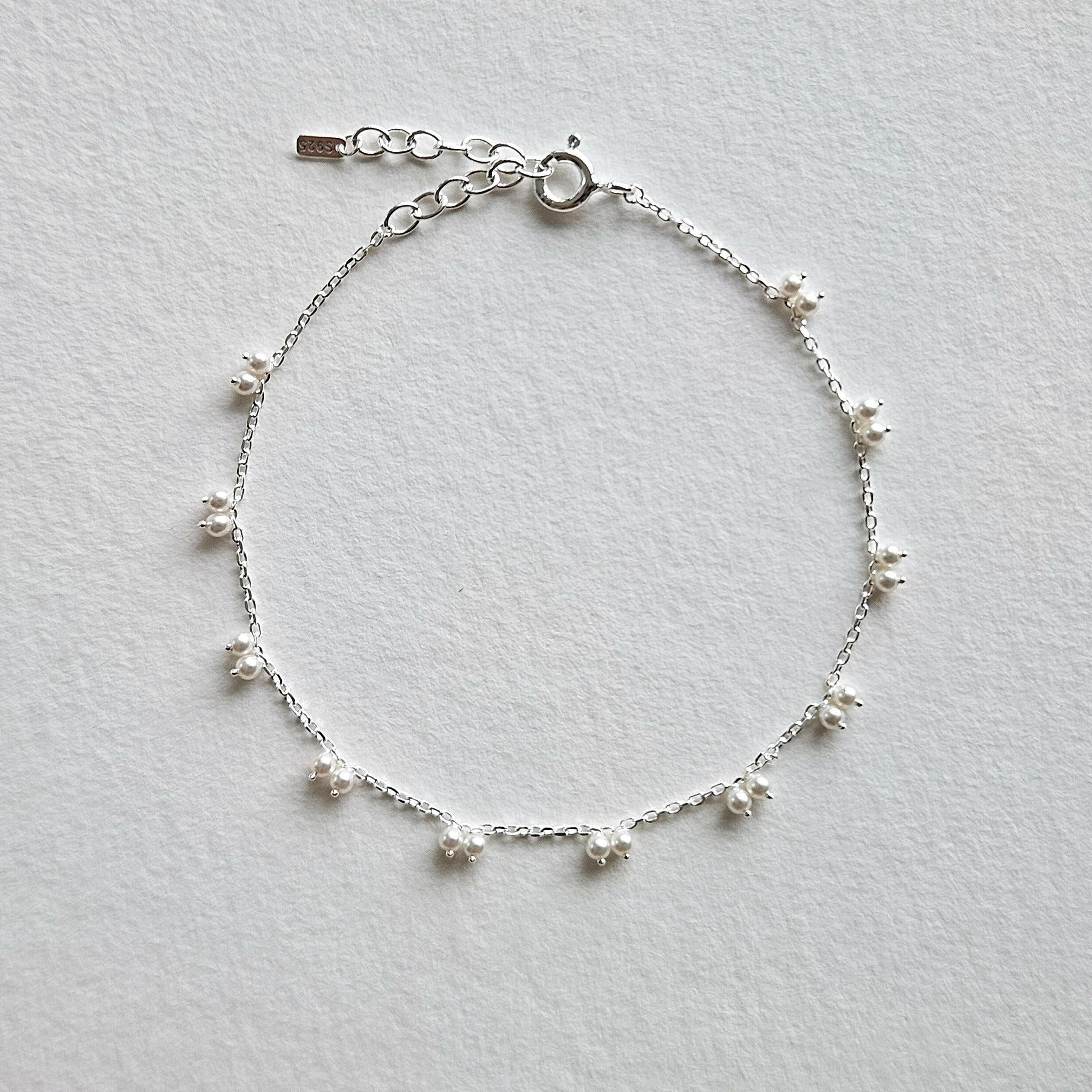 Petite pearl bracelet featuring a pair of lustrous small pearls artfully entwined for elegant style