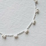 Petite pearl bracelet featuring a pair of lustrous small pearls artfully entwined for elegant style