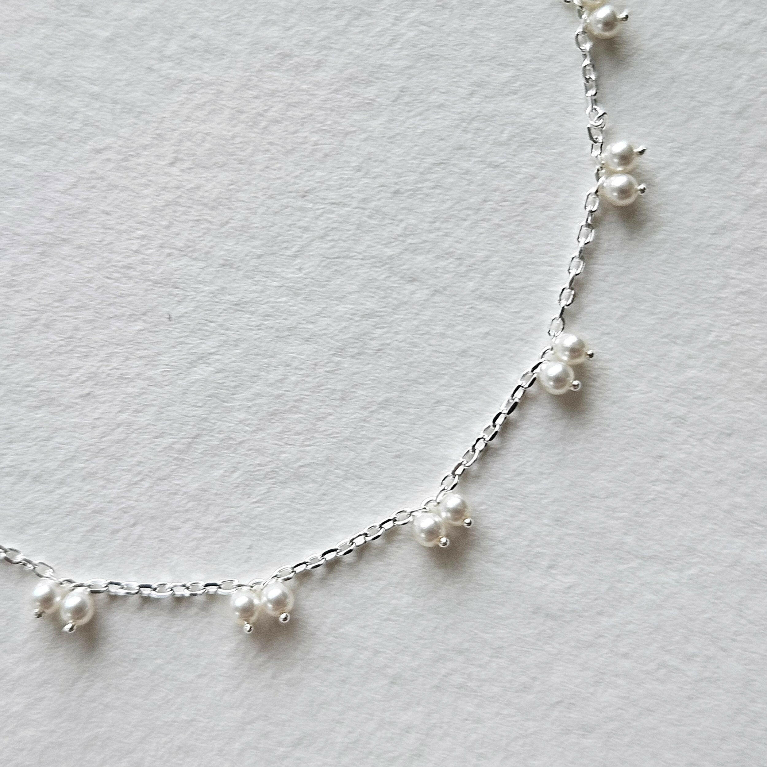 Petite pearl bracelet featuring a pair of lustrous small pearls artfully entwined for elegant style