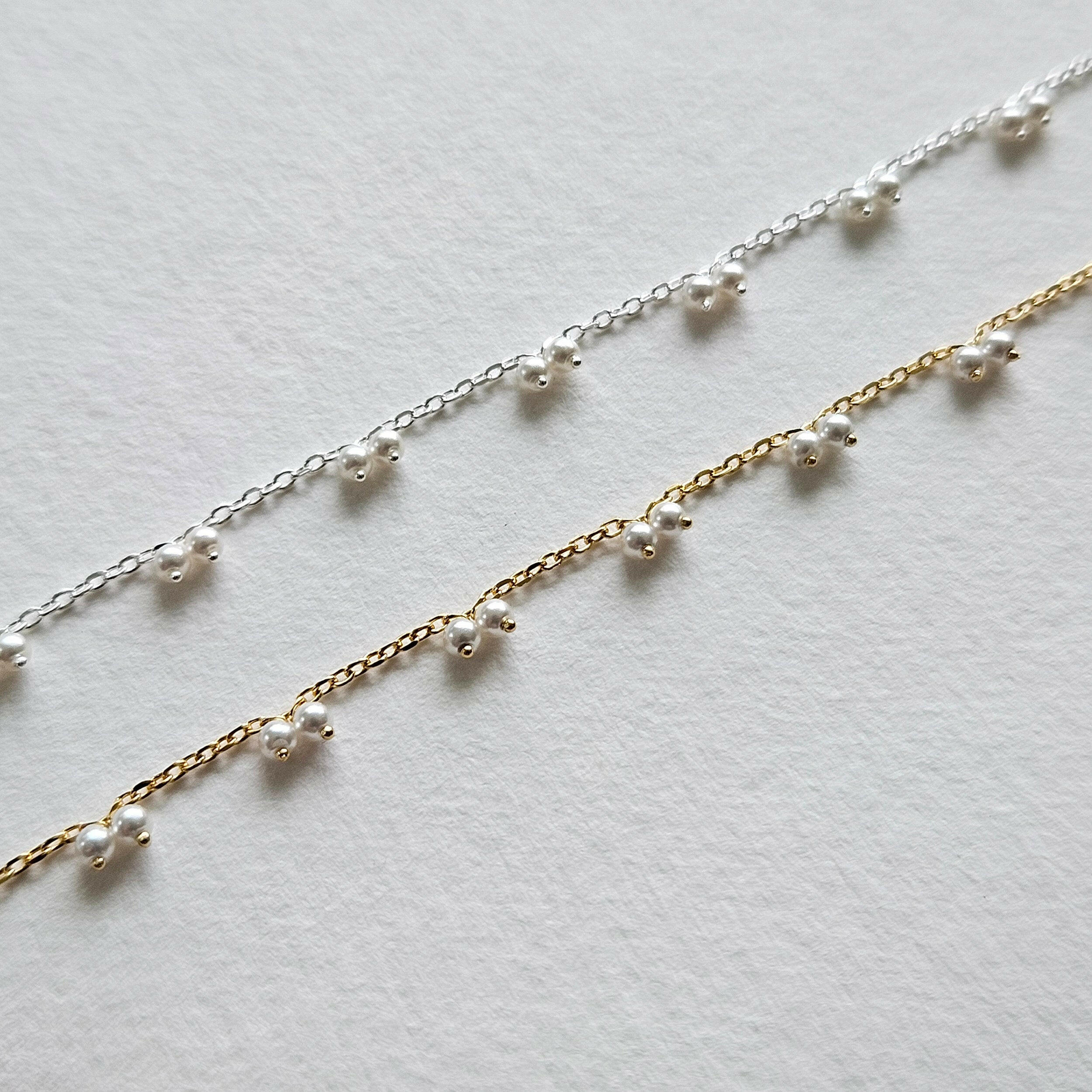 Petite pearl bracelet featuring a pair of lustrous small pearls artfully entwined for elegant style