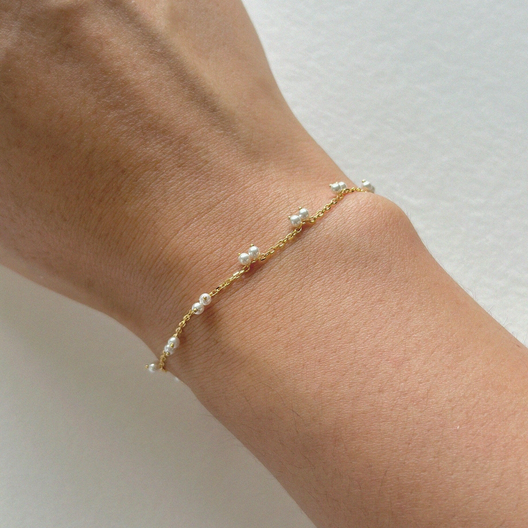 Petite pearl bracelet featuring a pair of lustrous small pearls artfully entwined for elegant style