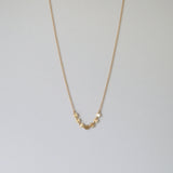 Gold filled necklace with 7 pressed disc charms laid flat