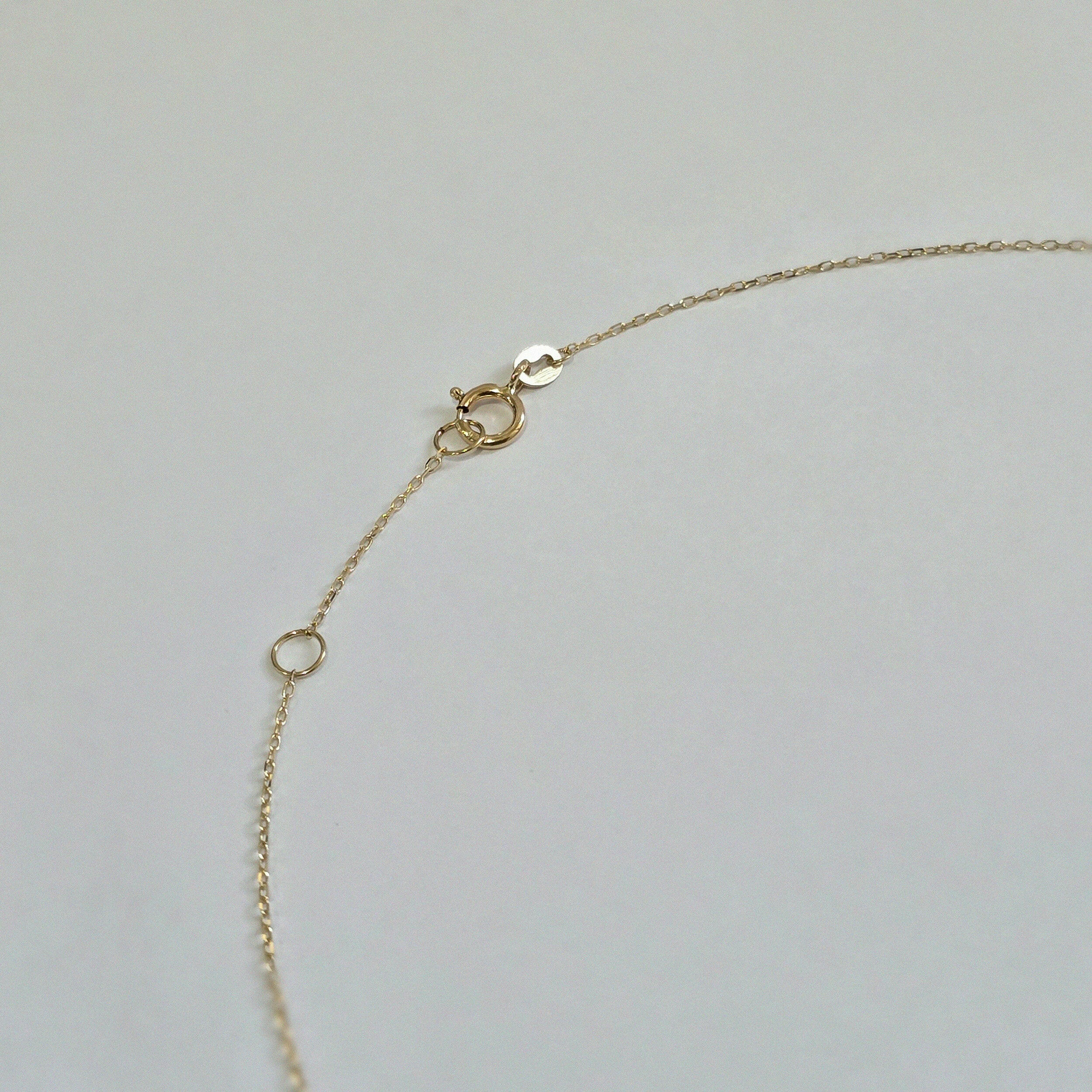 Clasp and extender of pearl necklace shown in secure, polished finish