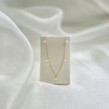 Ariel Perla Necklace displayed on cream leather necklace stand, pearls symmetrically aligned