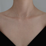 Necklace styled with a black off-shoulder top for an elegant, understated look