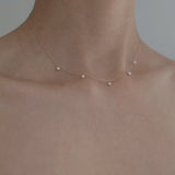 Side shot of model wearing Ariel Perla Necklace, pearls sitting gracefully at collarbone