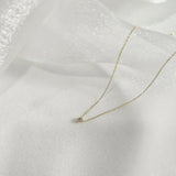 Slight side angle of necklace capturing depth and light reflection from pendant