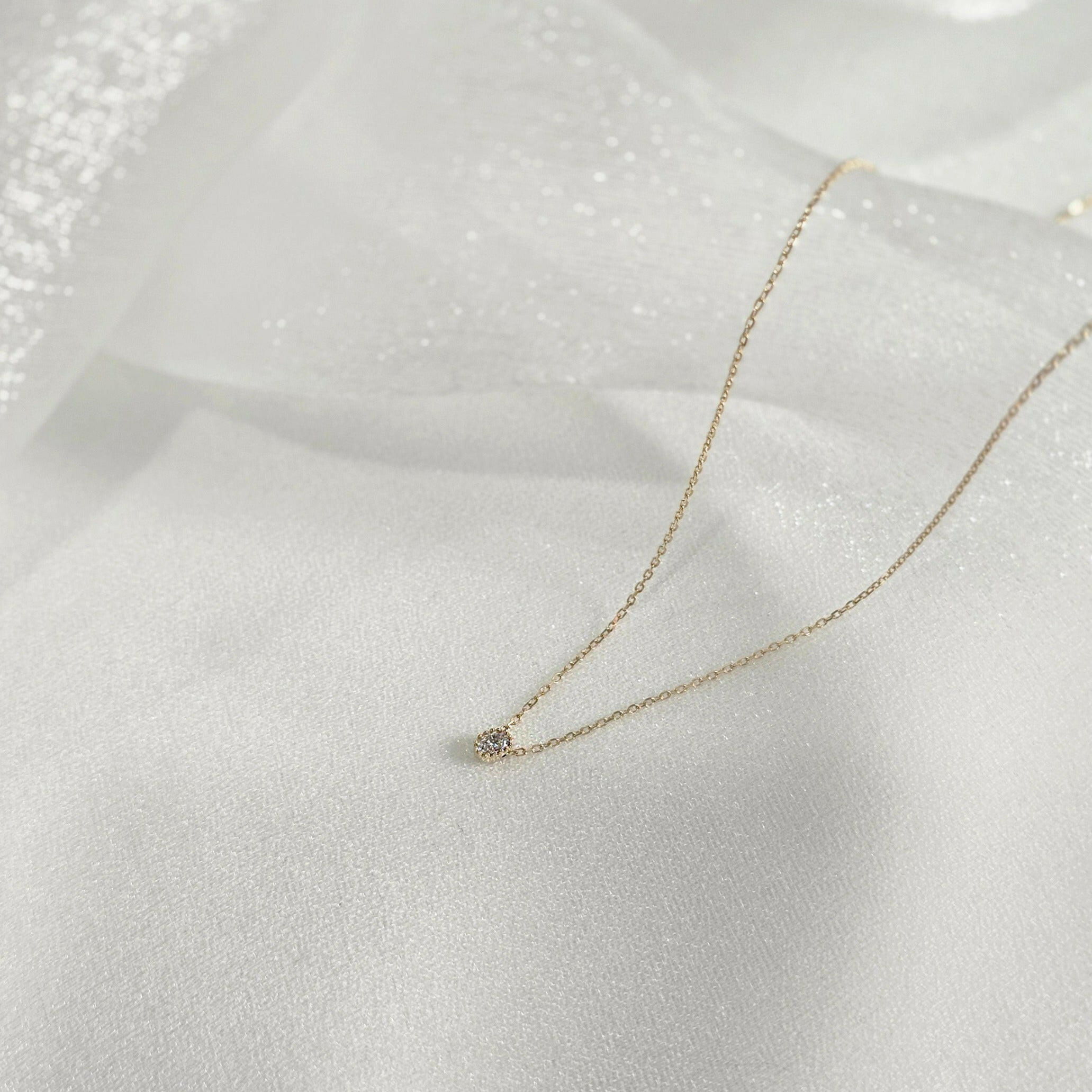 Slight side angle of necklace capturing depth and light reflection from pendant