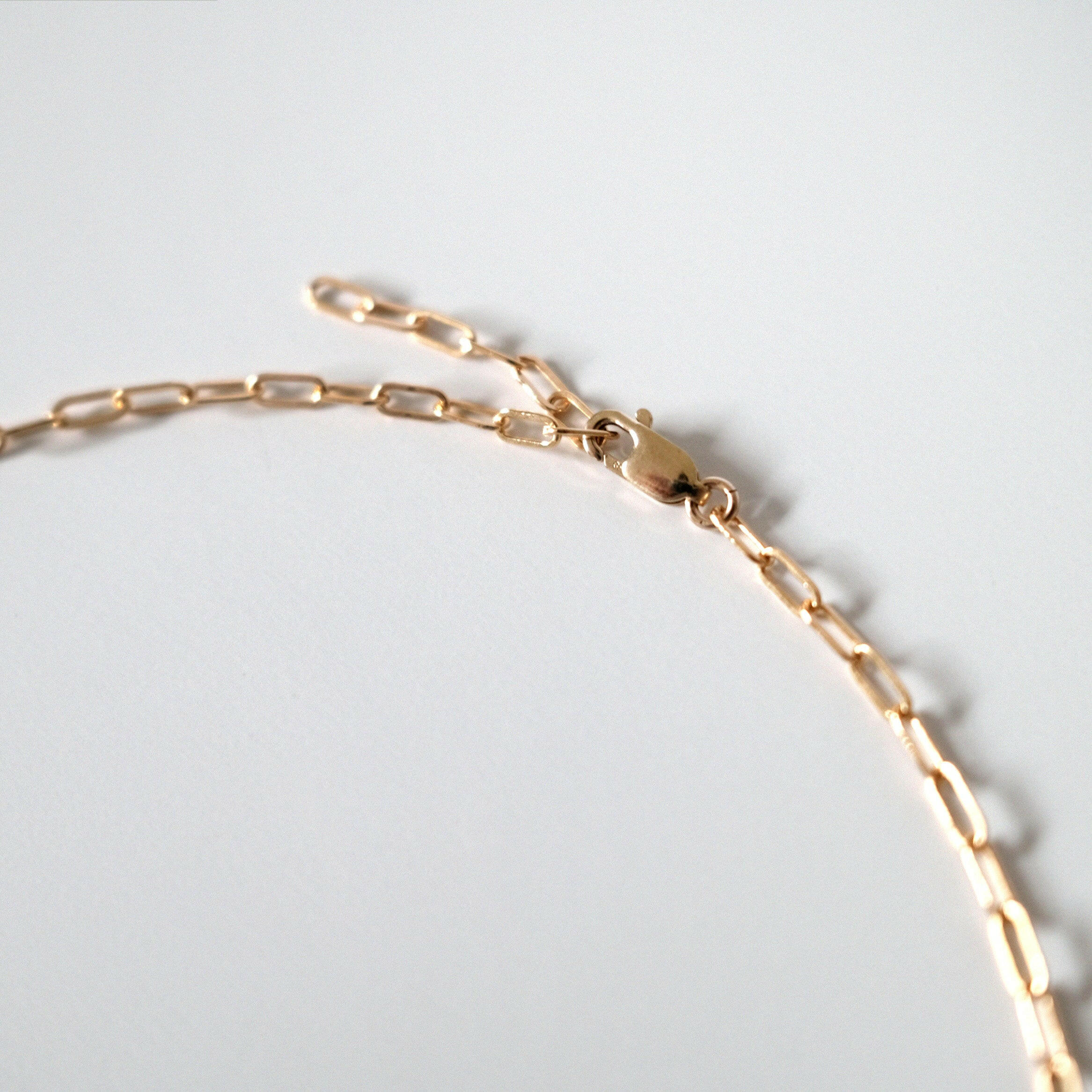 Close-up of lobster clasp attached to a middle link for custom fit