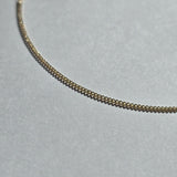 Macro view highlighting the sculptural curve of the gold chain