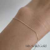 Model wearing the Capri Chain Bracelet solo, showing curved gold links on wrist