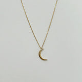 Close-up of 14mm crescent moon pendant in high-polish 14K gold, symbolizing femininity and intuition