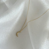 Close-up of 14mm crescent moon pendant in high-polish 14K gold, symbolizing femininity and intuition