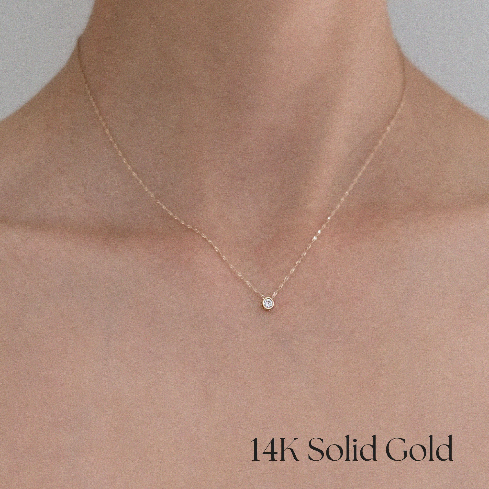 Close-up of model’s neckline wearing Laondrim 14K gold necklace, subtle sparkle of cubic zirconia visible against skin
