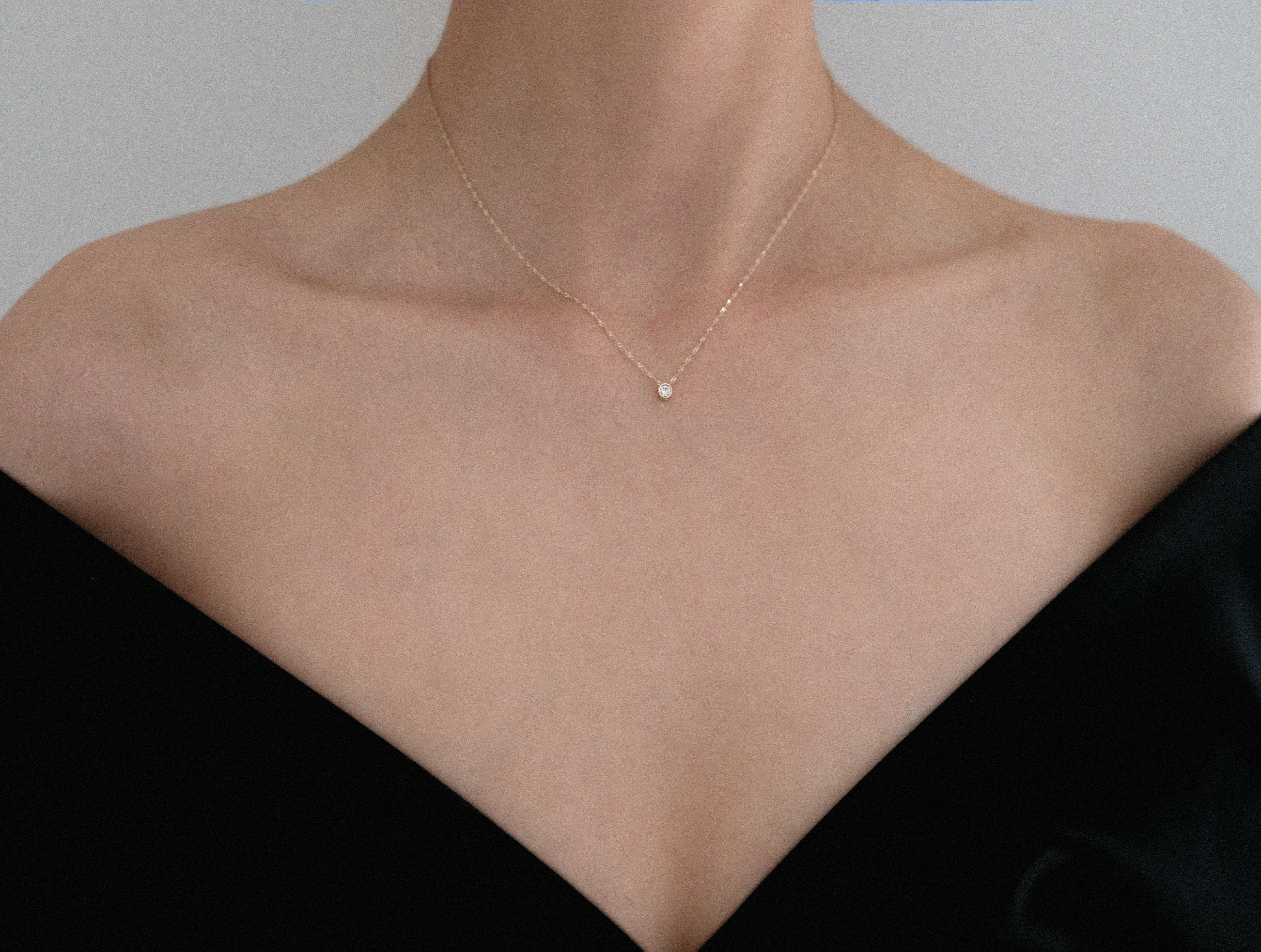 Model wearing the Crystal Accent Necklace with a black off-shoulder top, minimalistic styling