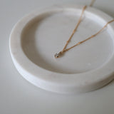 Side angle close-up of cubic zirconia charm and polished chain