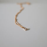 close-up of cubic zirconia charm and polished chain