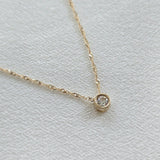 Side profile of 14K gold chain with cubic zirconia accent, reflecting light