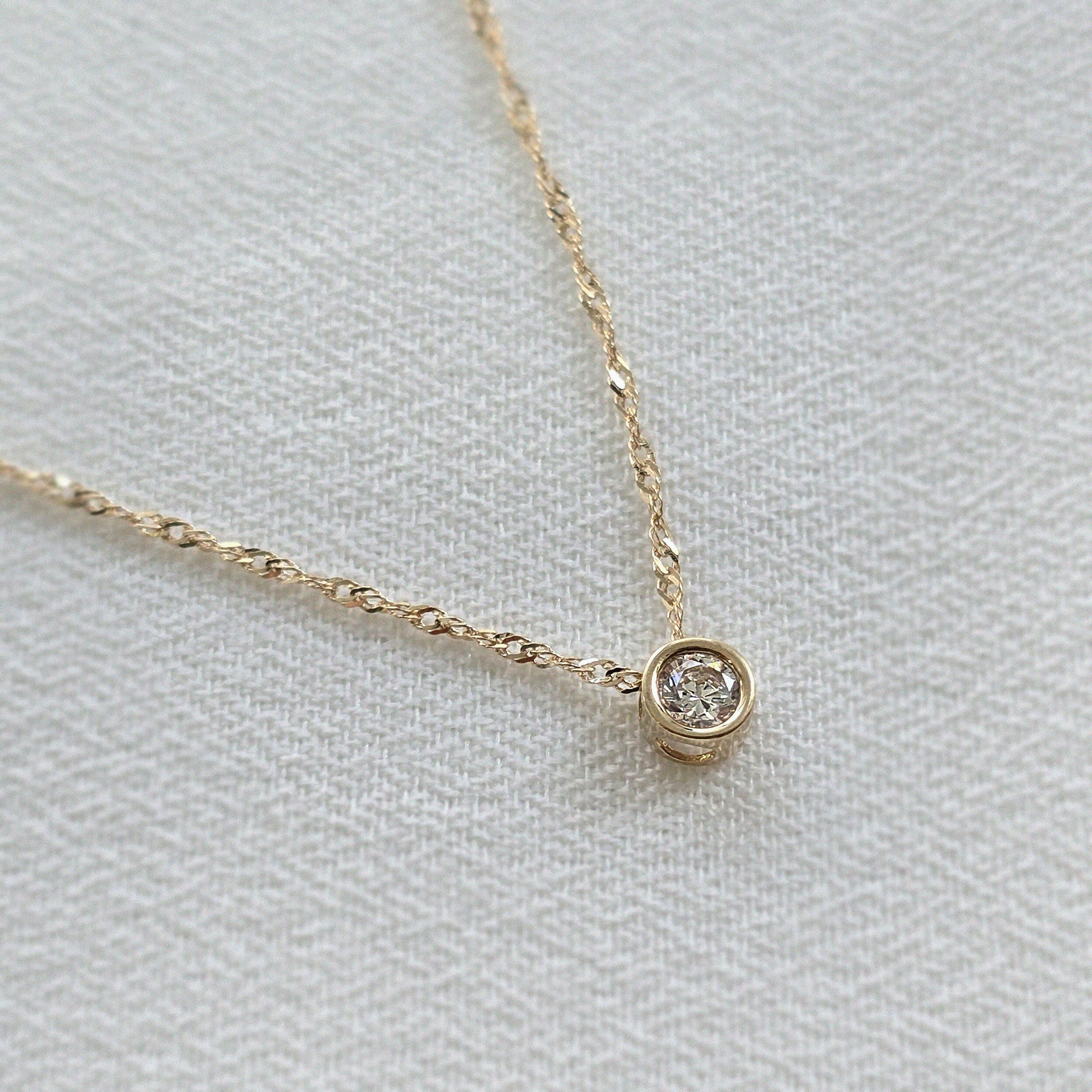 Side profile of 14K gold chain with cubic zirconia accent, reflecting light