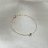 Dainty gold chain bracelet with brilliant diamond detail styled in soft light